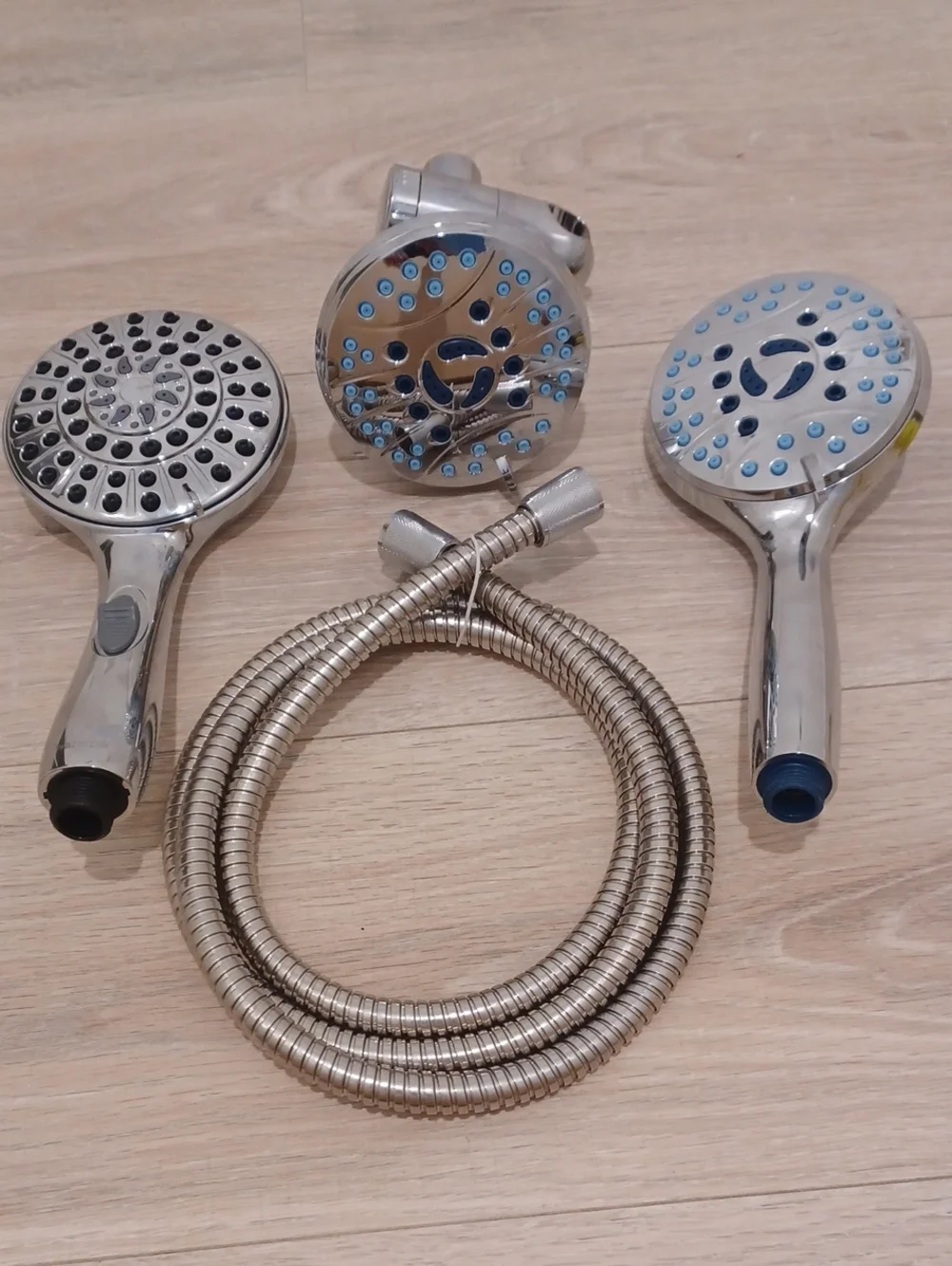 Bundle of chrome shower heads with flexible hose. Bath. Hand held.